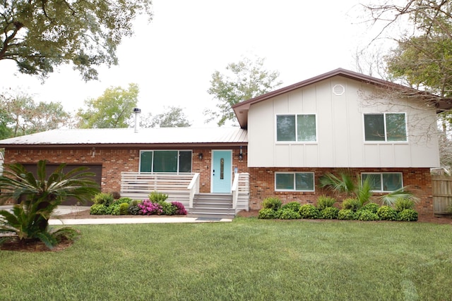 split level home with a front yard, brick siding, and an attached garage