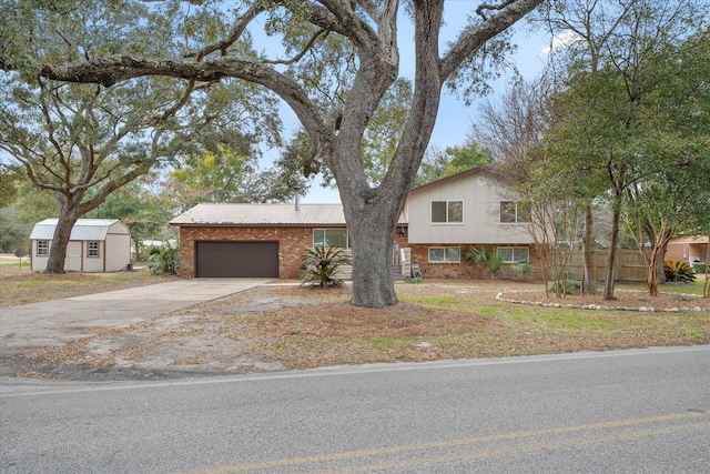 tri-level home with driveway, an attached garage, metal roof, and brick siding