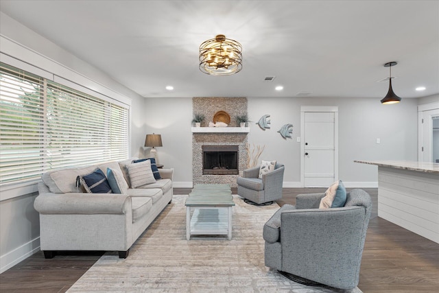 living room with a large fireplace, baseboards, wood finished floors, and recessed lighting