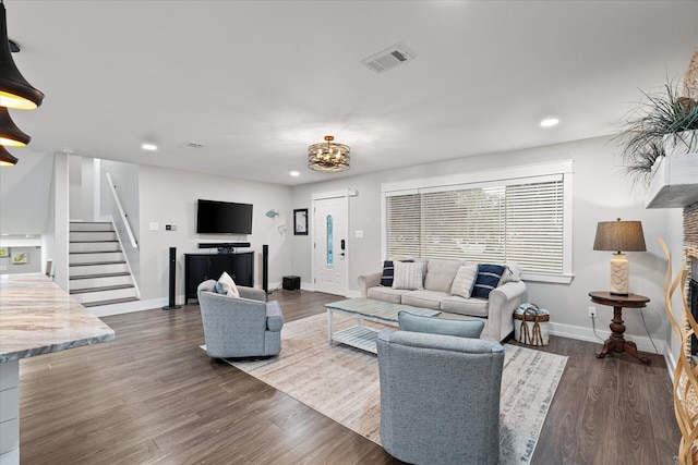 living area featuring stairs, dark wood-style flooring, visible vents, and baseboards