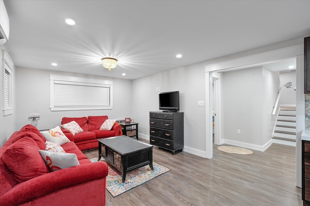 living area featuring recessed lighting, baseboards, stairs, light wood-style floors, and a wall mounted AC