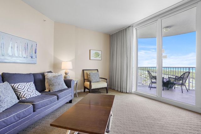 carpeted living room featuring a water view and a wall of windows