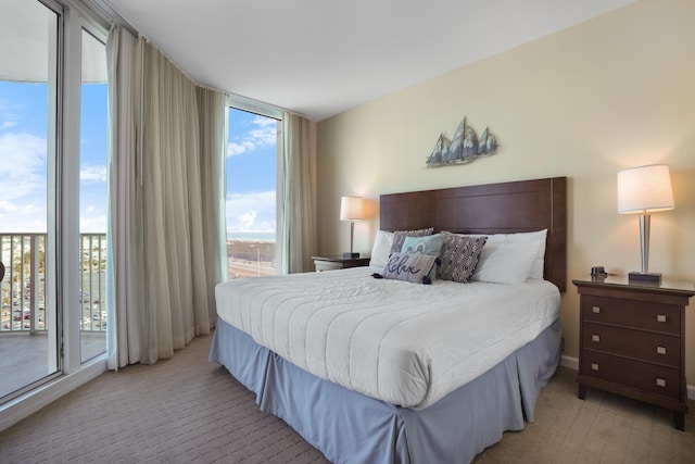 carpeted bedroom featuring expansive windows and access to outside