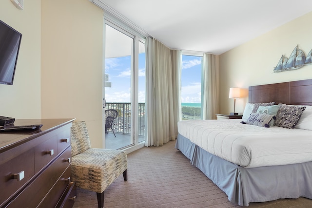 bedroom with a wall of windows, access to exterior, light carpet, and multiple windows