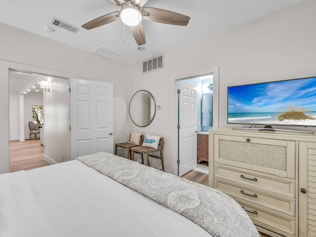 bedroom featuring ceiling fan, ensuite bathroom, and light wood-type flooring