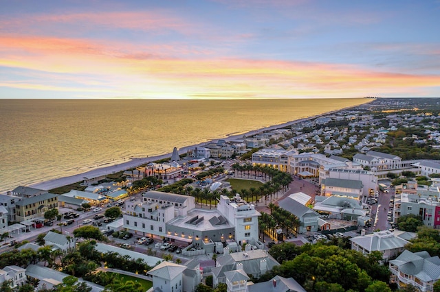 aerial view at dusk with a view of the beach and a water view