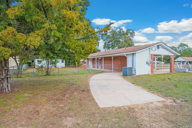 view of front of house with central AC unit and a front lawn