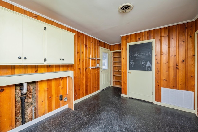 interior space featuring crown molding and wooden walls