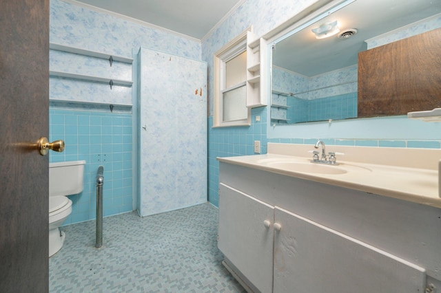 bathroom with crown molding, vanity, toilet, and tile walls