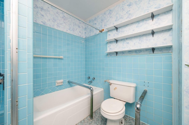 bathroom with crown molding, tiled shower / bath, toilet, and tile walls