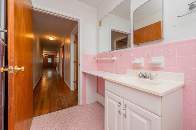 bathroom with tile walls, vanity, and ornamental molding