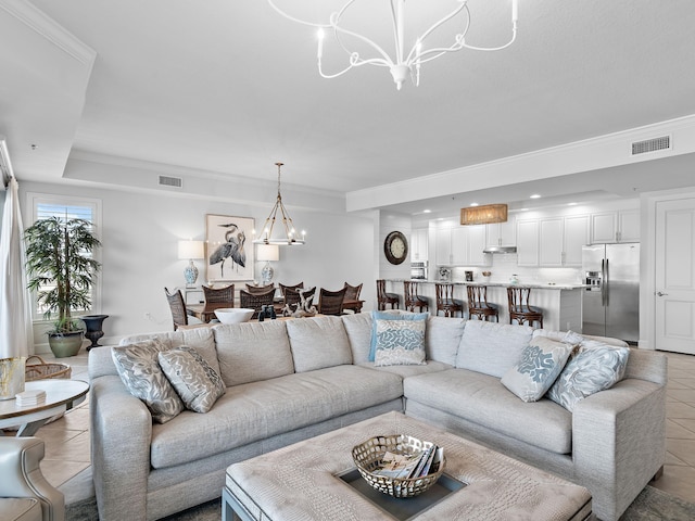 living room with an inviting chandelier, crown molding, and light tile patterned floors