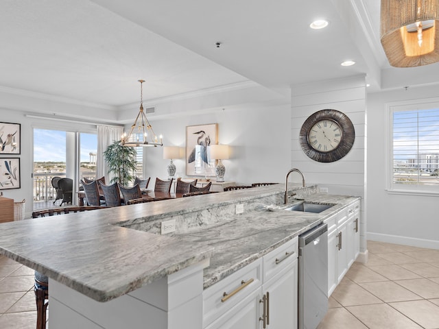 kitchen featuring white cabinetry, stainless steel dishwasher, sink, and a wealth of natural light