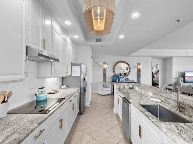 kitchen featuring sink, hanging light fixtures, appliances with stainless steel finishes, a raised ceiling, and white cabinets