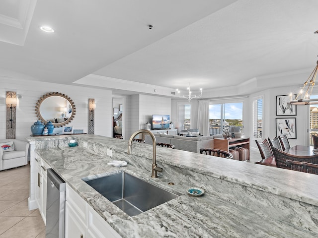 kitchen with light tile patterned flooring, sink, stainless steel dishwasher, a notable chandelier, and white cabinets