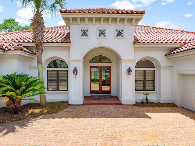 416 Admiral Ct, Destin, FL 32541 - property entrance with french doors, a tile roof, stucco siding, and an attached garage