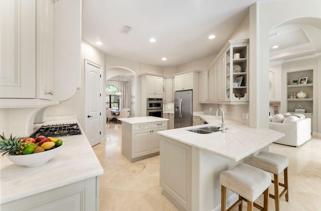 416 Admiral Ct, Destin, FL 32541 - kitchen featuring a sink, stainless steel appliances, arched walkways, a breakfast bar area, and recessed lighting