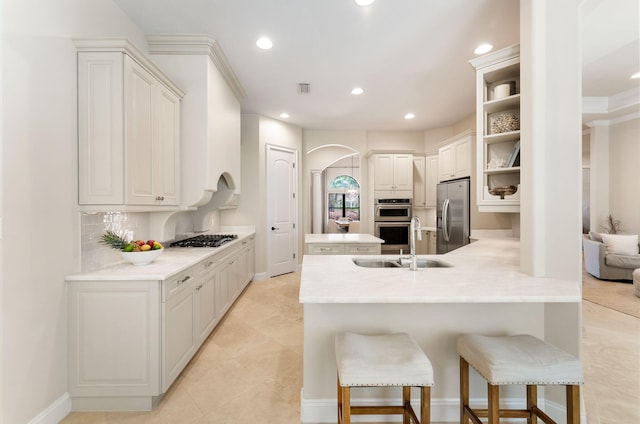 416 Admiral Ct, Destin, FL 32541 - kitchen featuring stainless steel appliances, a peninsula, arched walkways, a kitchen breakfast bar, and recessed lighting