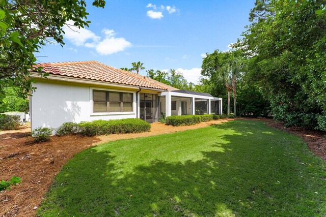 416 Admiral Ct, Destin, FL 32541 - rear view of property with a tiled roof, a yard, stucco siding, and a sunroom