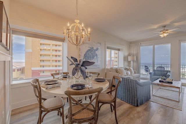 dining area featuring ceiling fan with notable chandelier and light hardwood / wood-style flooring