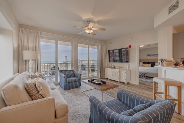 living room with ceiling fan and light hardwood / wood-style floors