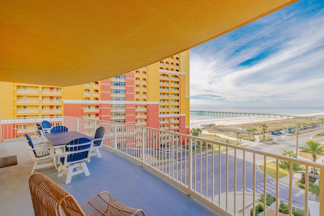 balcony featuring a water view and a view of the beach