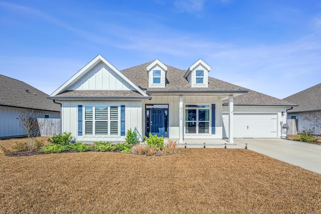 view of front facade featuring a garage, concrete driveway, board and batten siding, and roof with shingles