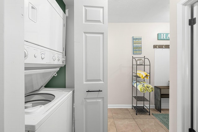 laundry room featuring stacked washer and dryer and light tile patterned flooring