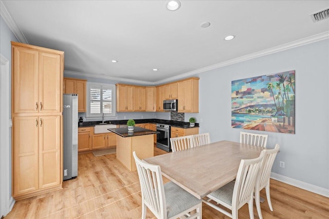 kitchen with sink, ornamental molding, a center island, stainless steel appliances, and light brown cabinets