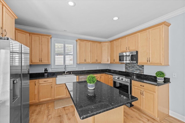 kitchen with sink, crown molding, a center island, dark stone counters, and stainless steel appliances