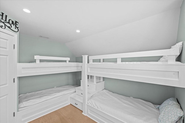 bedroom featuring lofted ceiling and light hardwood / wood-style flooring