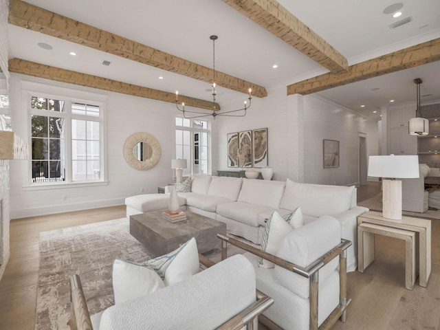 living room featuring beamed ceiling, a chandelier, and light wood-type flooring