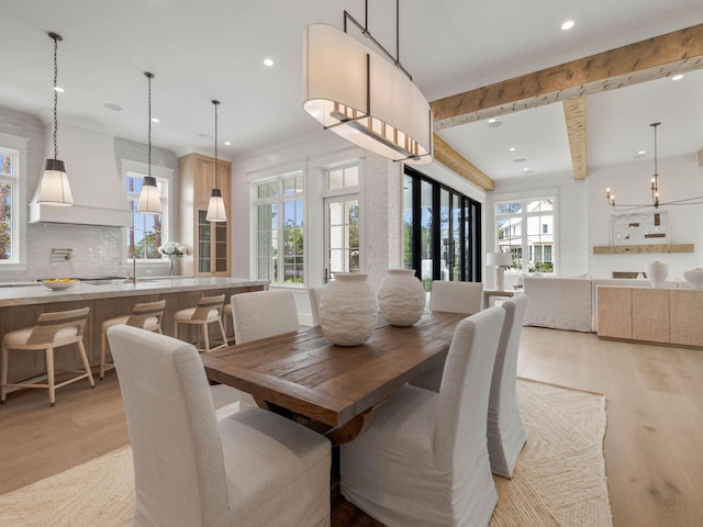 dining room with beam ceiling and light wood-type flooring