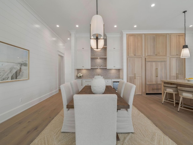 dining area featuring crown molding and light hardwood / wood-style flooring