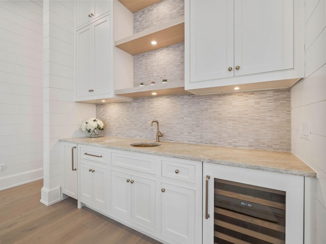 bar with white cabinets, sink, beverage cooler, and decorative backsplash