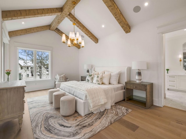 bedroom featuring lofted ceiling with beams, connected bathroom, a notable chandelier, and light wood-type flooring