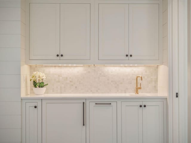 details featuring tasteful backsplash and sink