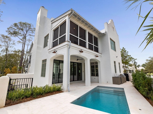 rear view of house with a fenced in pool, a patio, and ceiling fan