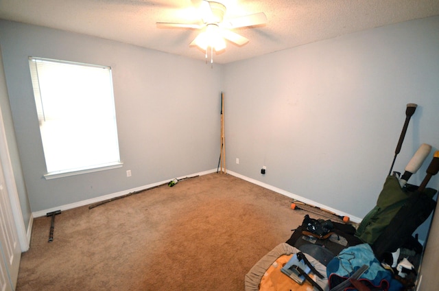 unfurnished room with ceiling fan, carpet flooring, and a textured ceiling