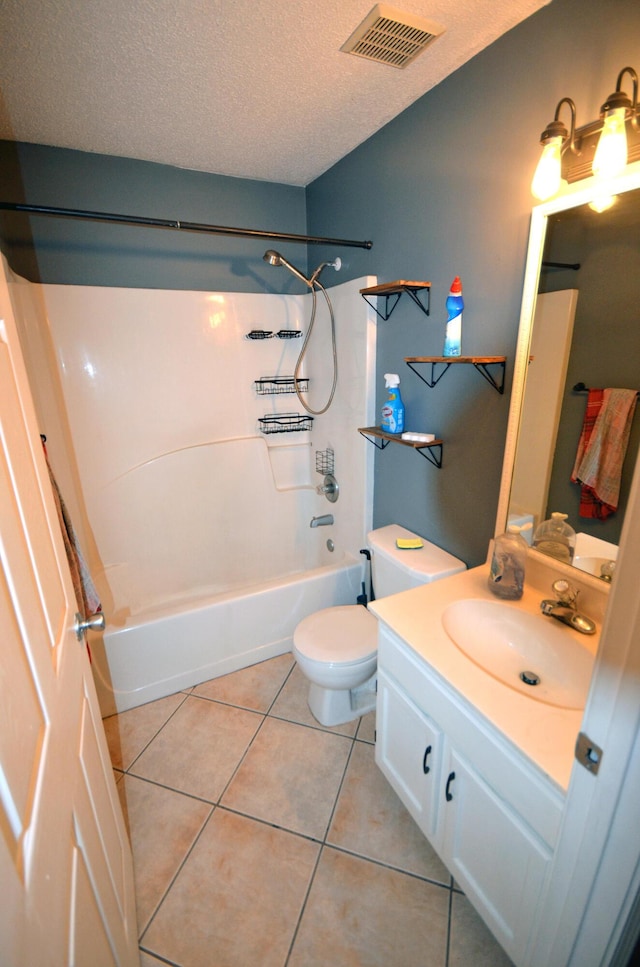 full bathroom featuring tile patterned floors, toilet, a textured ceiling, shower / washtub combination, and vanity