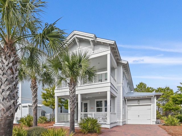 view of front facade with a garage, a balcony, and a porch