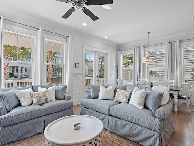 living room featuring hardwood / wood-style flooring, ornamental molding, and ceiling fan