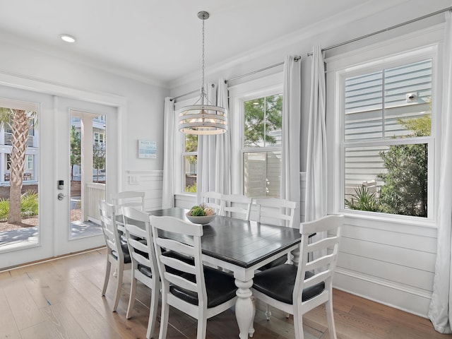 dining area with an inviting chandelier, ornamental molding, hardwood / wood-style floors, and french doors