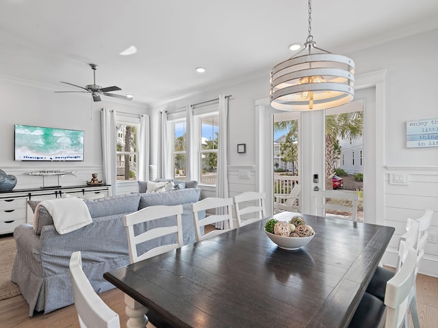 dining area with ceiling fan, ornamental molding, and light hardwood / wood-style flooring