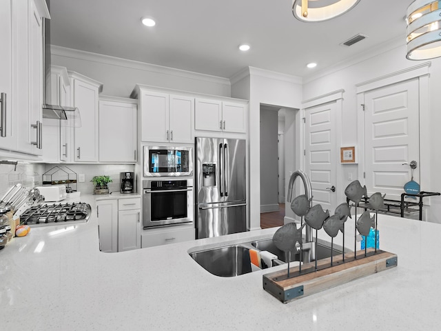 kitchen featuring stainless steel appliances, white cabinetry, ornamental molding, and tasteful backsplash