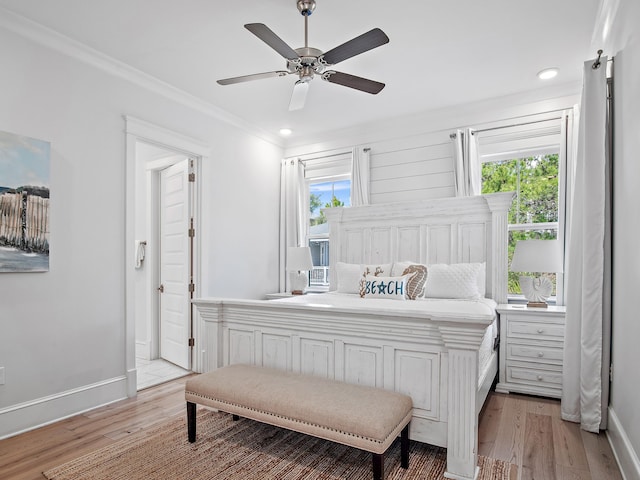 bedroom with ornamental molding, multiple windows, and light hardwood / wood-style flooring