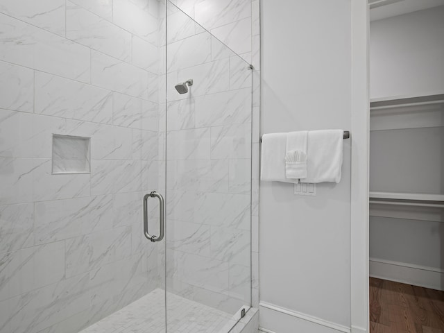 bathroom featuring wood-type flooring and a shower with shower door