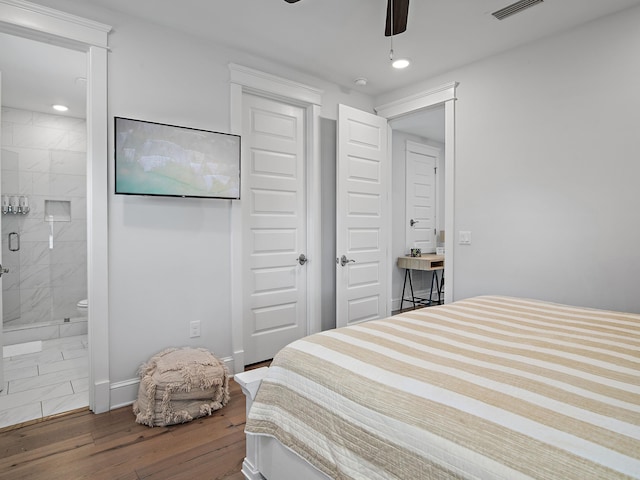 bedroom featuring dark wood-type flooring, connected bathroom, ceiling fan, and a closet