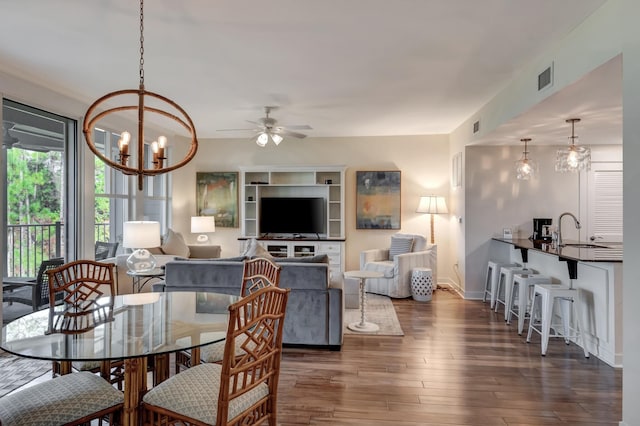 dining room with sink, ceiling fan with notable chandelier, and dark hardwood / wood-style floors