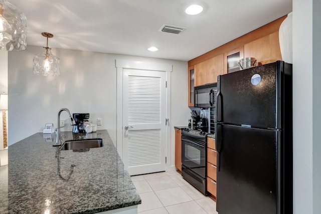 kitchen featuring pendant lighting, sink, dark stone countertops, light tile patterned floors, and black appliances